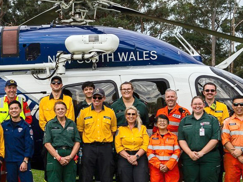 Several people from emergency services standing in front of a helicopter