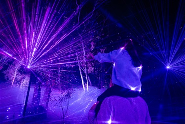 Child on Adults Shoulders in Laser Light