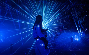 Girl on farher's shoulders surrounded by blue laser beam light