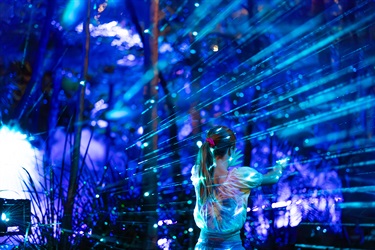 Girl interacting and touching blue laser light